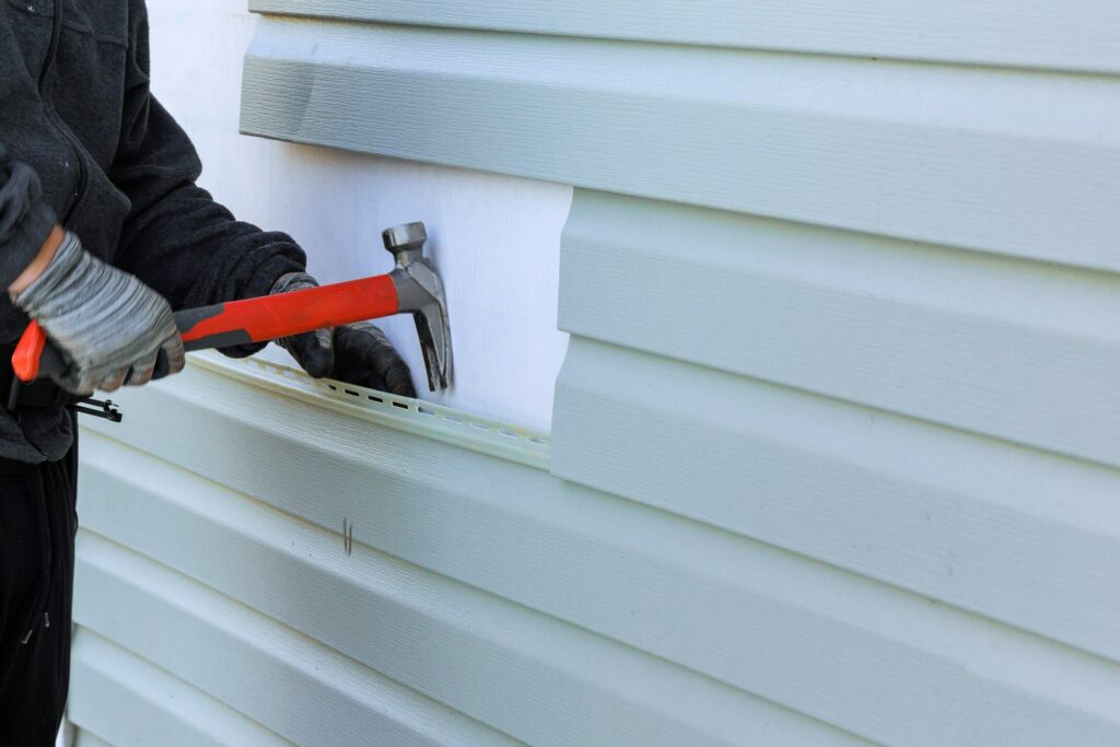 Reconstruction of exterior of house includes replacement of damaged plastic a siding