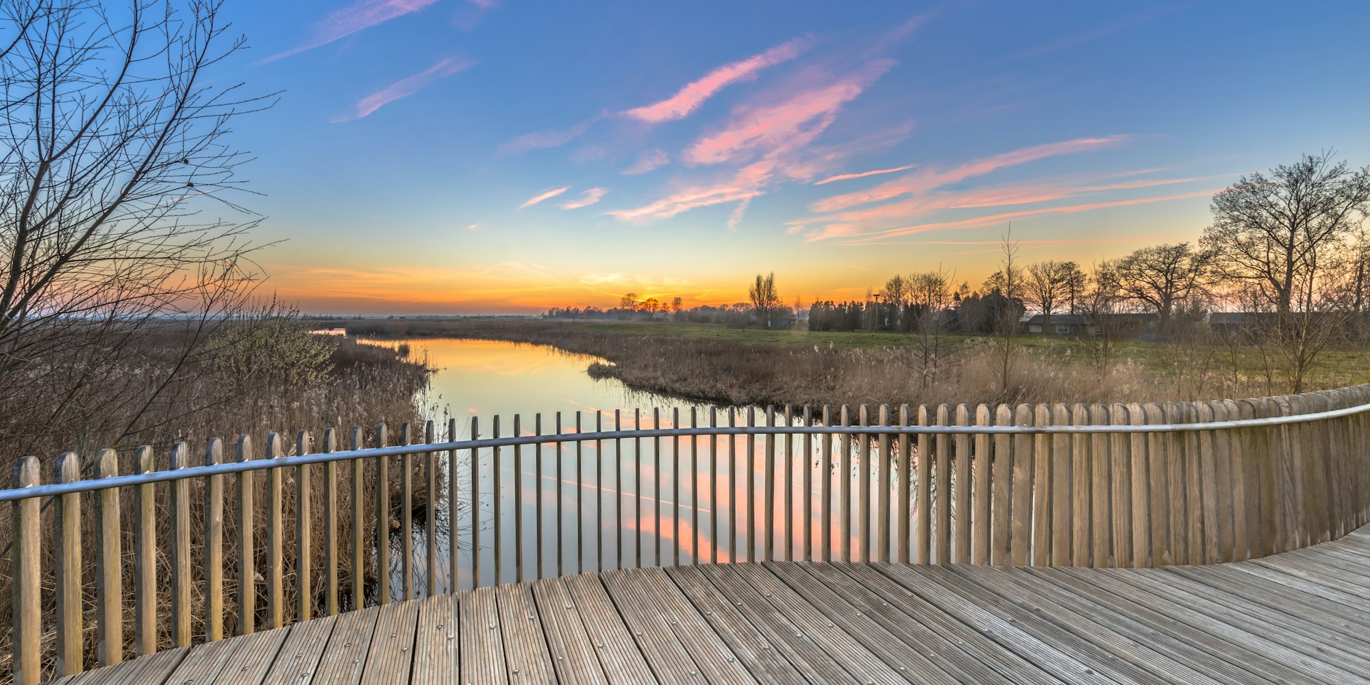 Wooden deck balustrade sunset over swamp